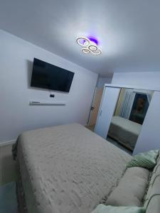 a bedroom with a bed and a flat screen tv at Alezzi Odyssey in Mamaia Nord