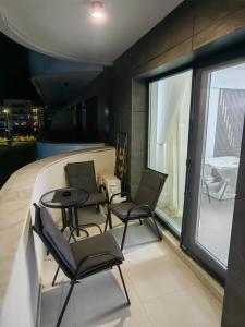 two chairs and a table in a room with a window at Alezzi Odyssey in Mamaia Nord