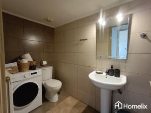 a bathroom with a toilet and a sink and a washing machine at C&K Beach Bungalow in Lefkandi Chalkidas