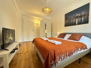 a bedroom with a bed and a flat screen tv at M Lorry Frida cosy au rdc avec balcon proche Metz in Metz