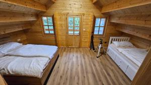 two beds in a room with wooden walls at Poloniny Osadne in Osadné