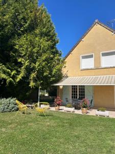 a yard with two chairs and a house at Maison la belle vue in Nogent-le-Rotrou