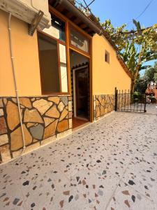 a house with a stone wall and a door at Green Door House in Vlorë