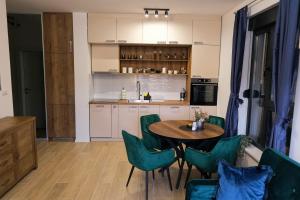 a kitchen with a table and green chairs at Studio 83 in Požega