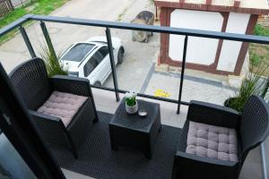 - un balcon avec deux chaises, une table et une voiture dans l'établissement Studio 83, à Požega