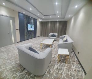 a living room with two couches and a table at اجنحة امجاد السلام طيبة in Medina