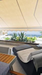 a bedroom with two beds and a view of plants at Anesis in Néa Péramos