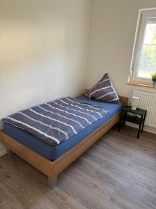 a bedroom with a bed with a blue comforter and a window at Ferienwohnung Silas in Haiger