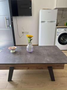 a table in a kitchen with a vase with flowers on it at Xenia's Resorts in Ofrínion +2 photos