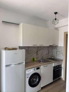 a white kitchen with a washing machine and a washer at Xenia's Resorts in Ofrínion