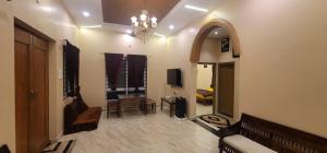 VenkatāpurにあるGolden nest farmsのシャンデリアのあるリビングルームとテレビのある部屋