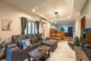 a living room with a couch and a table at Coastline Pearl Holiday Home, Bangtao Beach in Ban Thalat Choeng Thale