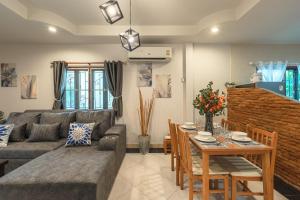 a living room with a couch and a table at Coastline Pearl Holiday Home, Bangtao Beach in Ban Thalat Choeng Thale