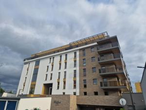 a tall white building with a brown at Apartament dworska Brzezno in Gdańsk