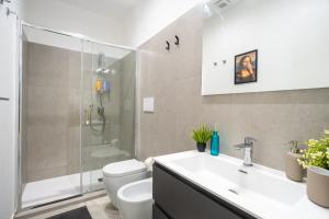 a bathroom with a sink and a toilet and a shower at Colorama Home in Catania