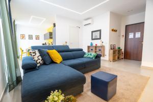 a living room with a blue couch and a table at Colorama Home in Catania