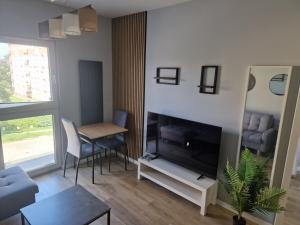 a living room with a television and a table at Apartament dworska Brzezno in Gdańsk