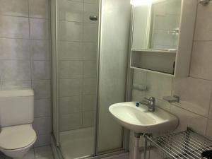 a bathroom with a toilet and a sink and a shower at Casa Migiur 3,5 Zimmer-Apartment in Laax +24 photos