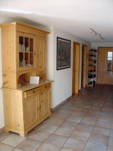 a kitchen with wooden cabinets and a tile floor at Casa Migiur 3,5 Zimmer-Apartment in Laax