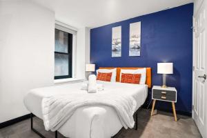 a bedroom with a large white bed with orange pillows at CozySuites Stunning 1BR in Downtown Pitts #3 in Pittsburgh