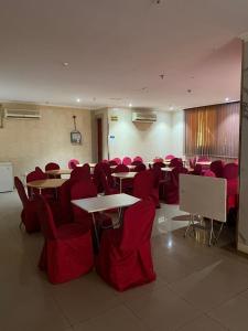 a room with tables and chairs and red chairs at فندق أركان الصفاء in Ajyad