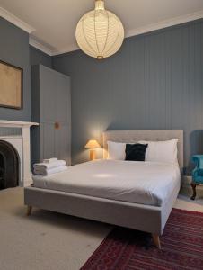 a bedroom with a large bed with a chandelier at Your CBD Treetop Base | Parking, Wifi & Views in Kings Park