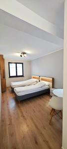 due letti in una stanza con pavimenti in legno di SWKD - Kameralne Apartamenty a Ostróda