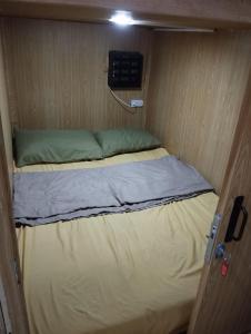 a small bed in a small room with a door at Capsule bed in Manila
