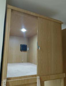 ajar door of a room with a bed in it at Capsule bed in Manila