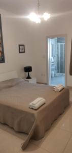 a bedroom with a large bed with two towels on it at Comfortable vacation home with great views in Mellieħa