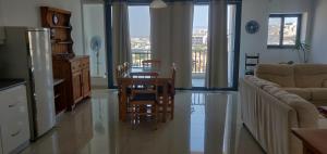a kitchen and living room with a table and a couch at Comfortable vacation home with great views in Mellieħa