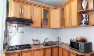 a kitchen with wooden cabinets and a microwave at Трёхкомнатная квартира на Ленина in Bender