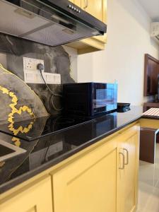 a kitchen with a black counter top with a microwave at High Tides End Ceylon Negombo in Negombo