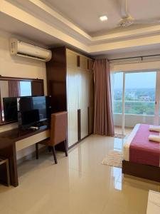 a hotel room with a desk and a bed and a computer at High Tides End Ceylon Negombo in Negombo