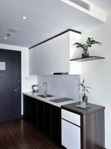 Una cocina con gabinetes blancos y un fregadero. en Em Apartment - Ocean and Lighthouse View, Sapphire Residence S2, en Ha Long