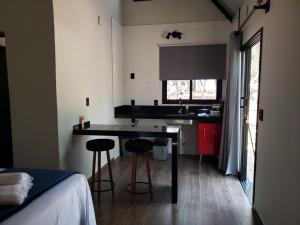 a kitchen with a table and two stools in a room at Tiny House na Pousada Hortelã-Pimenta in Itirapina
