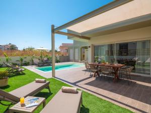 a patio with a table and chairs and a pool at Gournes - NewTown Residences in Gournes