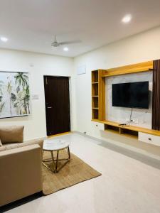 a living room with a couch and a flat screen tv at Your Homely Stay in kondapur in Kondapur