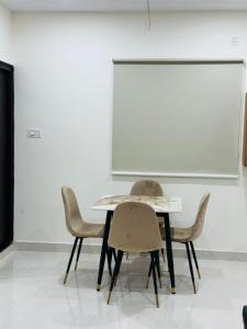 a table and chairs in a room with a whiteboard at Your Homely Stay in kondapur in Kondapur