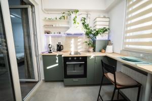 a small kitchen with green cabinets and a stove at Natural Luxury Studio Central Adress Residence in Bucharest