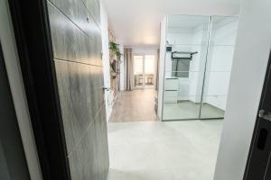 a hallway with a glass door and a mirror at Natural Luxury Studio Central Adress Residence in Bucharest +28 photos