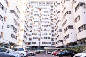 a large apartment building with cars parked in front of it at Natural Luxury Studio Central Adress Residence in Bucharest
