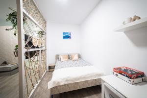 a bedroom with a bed in a white room at Natural Luxury Studio Central Adress Residence in Bucharest