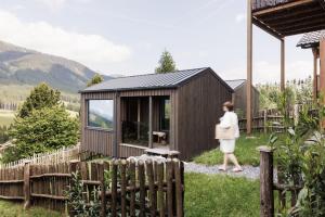 a woman walking in front of a wooden shed at Sloho Bergurlaub - Adults Only in Hohentauern