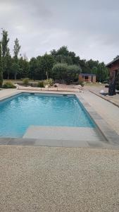 a swimming pool with blue water in a yard at Tiny House nature & détente, Vercors, terrasse, vue montagne in La Motte-Fanjas