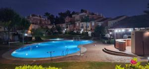 a large blue swimming pool at night with houses at Casa Ani Islantilla in Islantilla