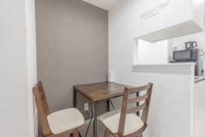 Una pequeña cocina con una mesa de madera y dos sillas. en 三ノ輪駅徒歩圏 交通便利 浅草観光 ショッピング グルメを満喫する日本堤ステイ DsL, en Tokio