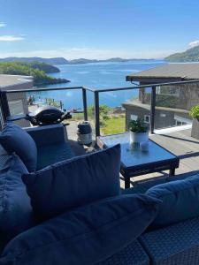 a living room with a couch and a view of the water at Sjønært drømmehus med panoramautsikt, nær Bergen in Ebbesvik +39 photos