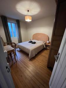 a bedroom with a bed and a chair and a window at LA MAISON DE CECILE jusqu'à 6 personnes en Normandie in Condé-sur-Vire
