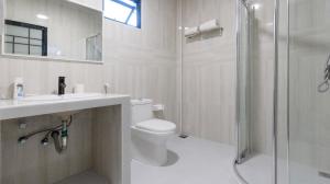 Un baño blanco con inodoro y ducha. en Jenyva Inn, en Thoddoo